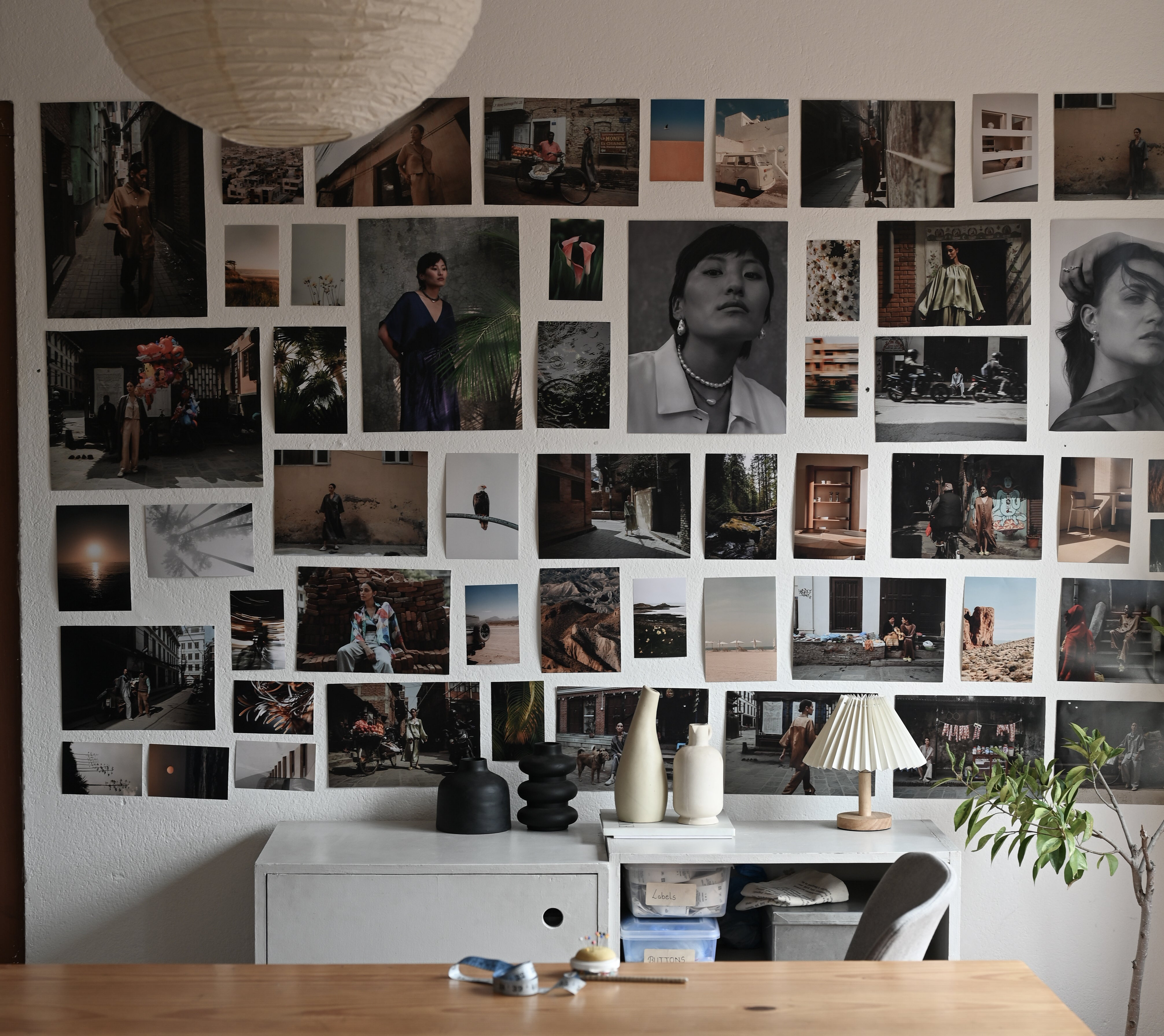 Modern office with a large wooden desk and wall of photographs